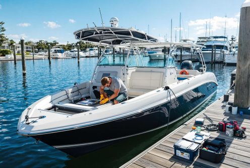 A technician in protective gloves opens a boat’s battery compartment for routine boat battery testing and replacement.