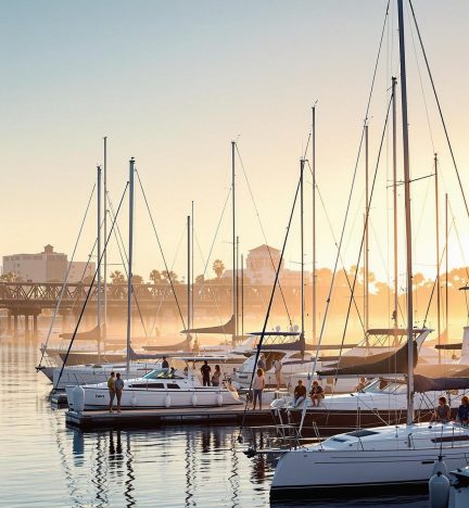 A tranquil evening with sailboats reflecting on calm waters, showcasing premium boat services at Loews Coronado Bay Marina.