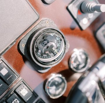 compass-near-the-control-panel-of-a-motor-boat